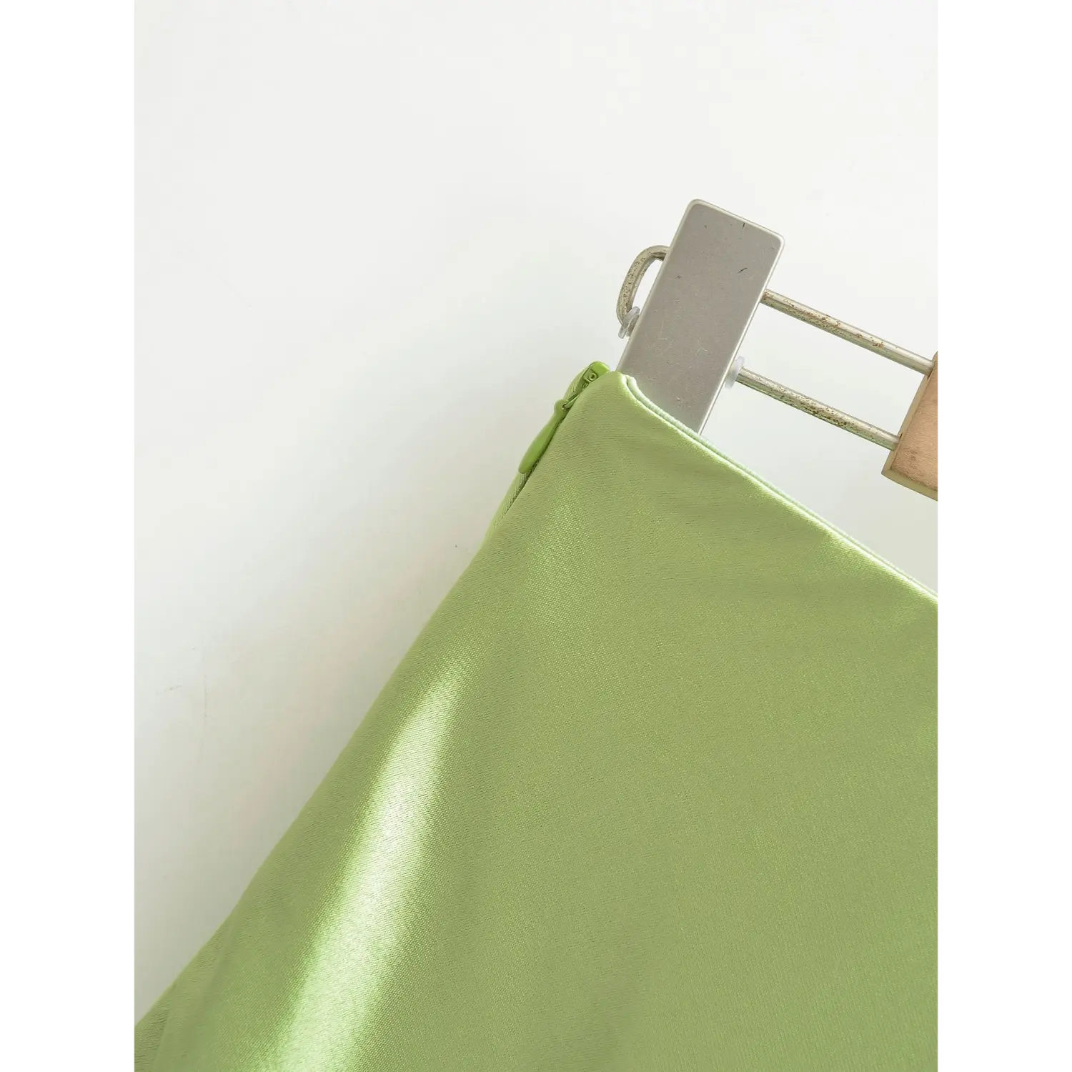 Real shot of hidden side zipper on avocado green satin skirt, matching green zipper with smooth craft details
