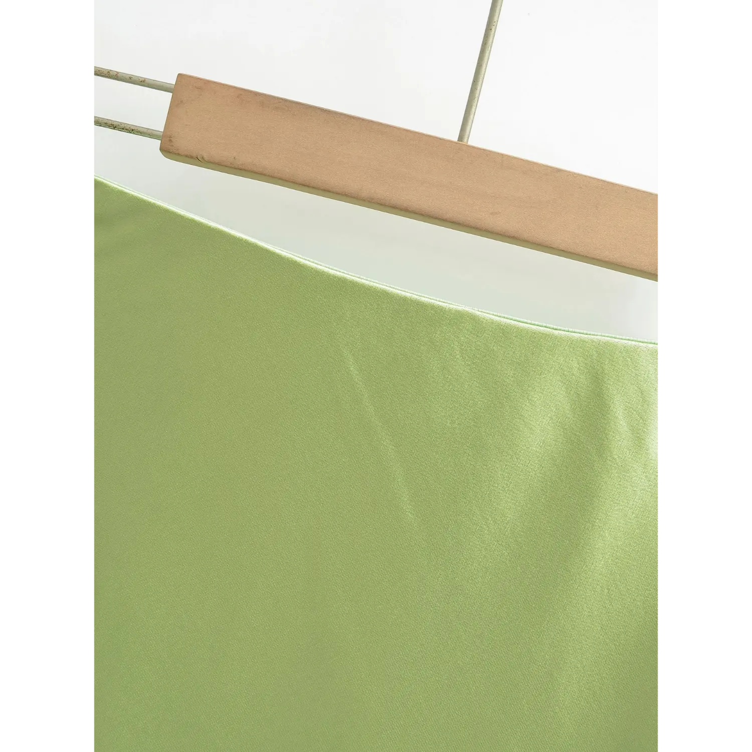 Avocado green satin skirt high waistband close-up, matched color neat binding, fine satin fabric texture display