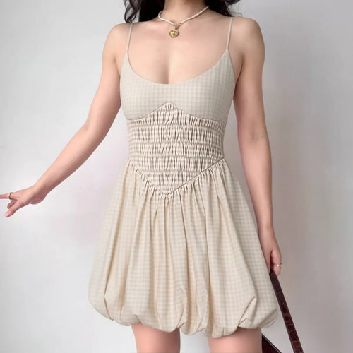 Model wearing beige gingham cami dress with bubble hem and smocked waist