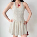Model in beige halter-neck eyelet mini dress, front view