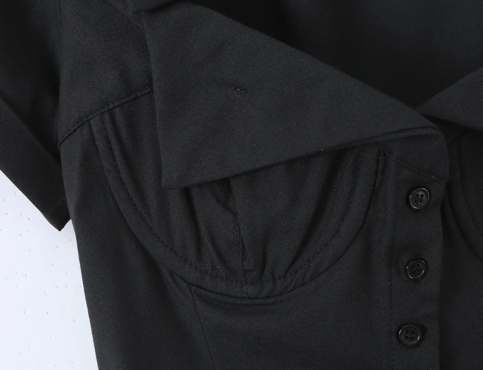 Close-up of the bustier-style cups and front button placket on the black corset shirt