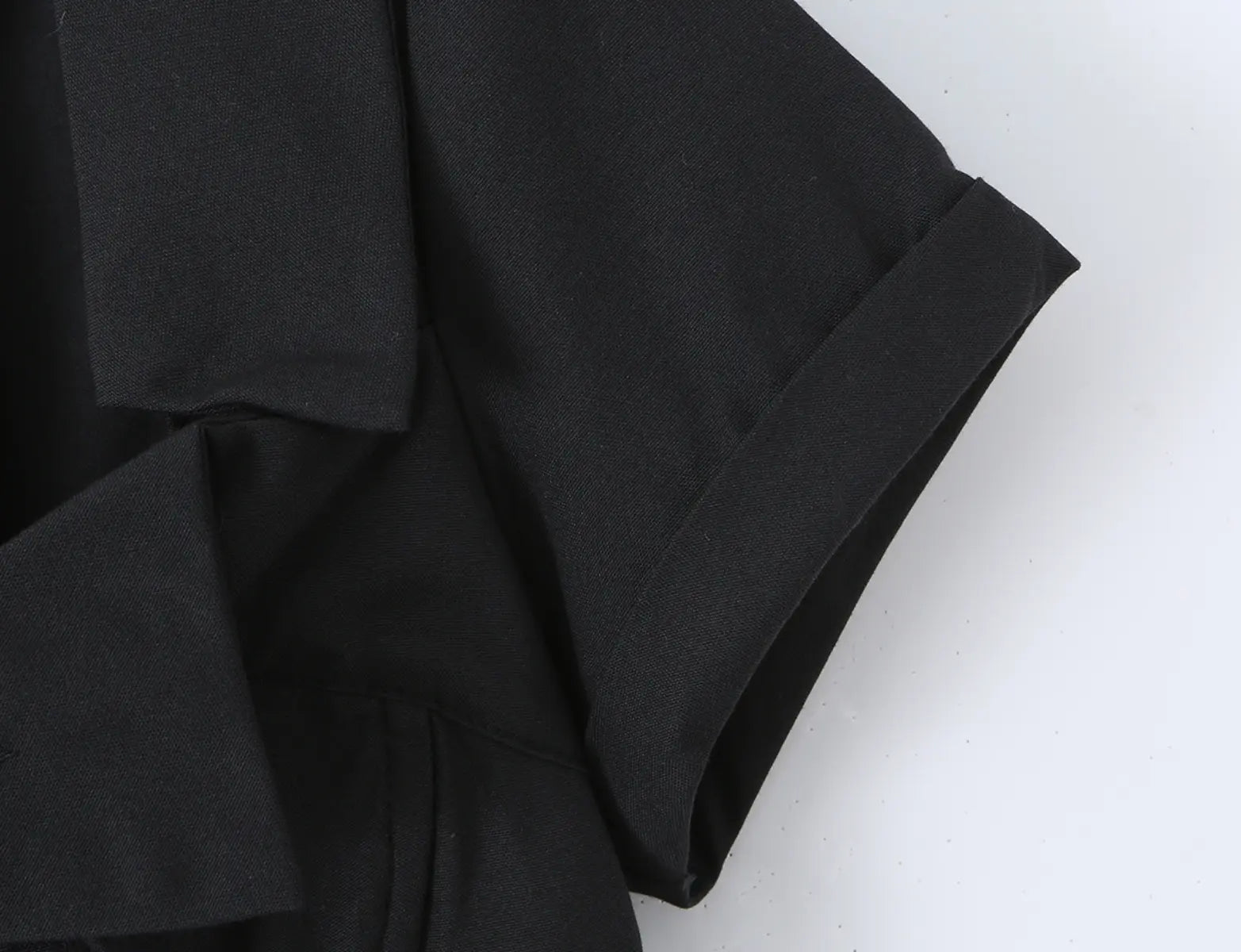 Close-up of the structured notched collar and short sleeve on the black corset shirt