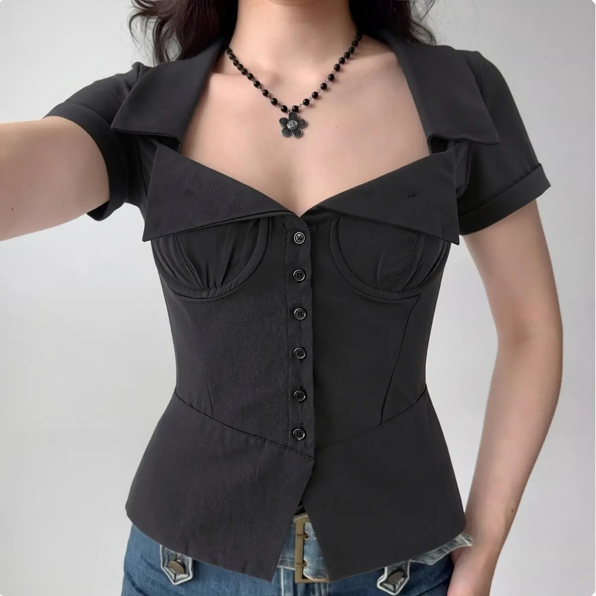 Model in black corset-style short-sleeve shirt, front view