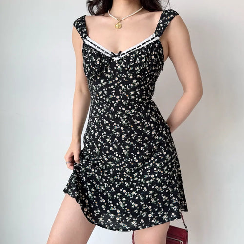 Model in black ditsy floral mini dress, front view