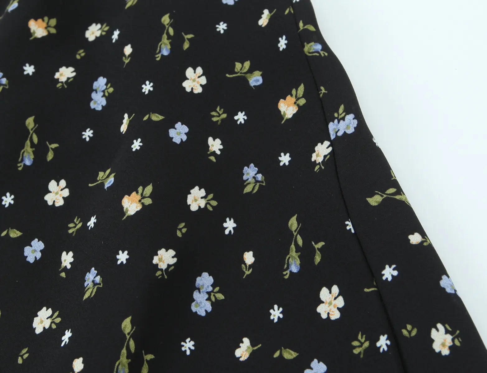 Close-up of ditsy floral print fabric on black halter mini dress