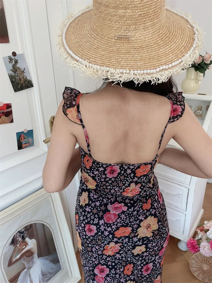 Back view of black floral cami maxi dress with ruffled straps and fitted silhouette