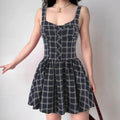 Model in black grid corset sleeveless mini dress, front view
