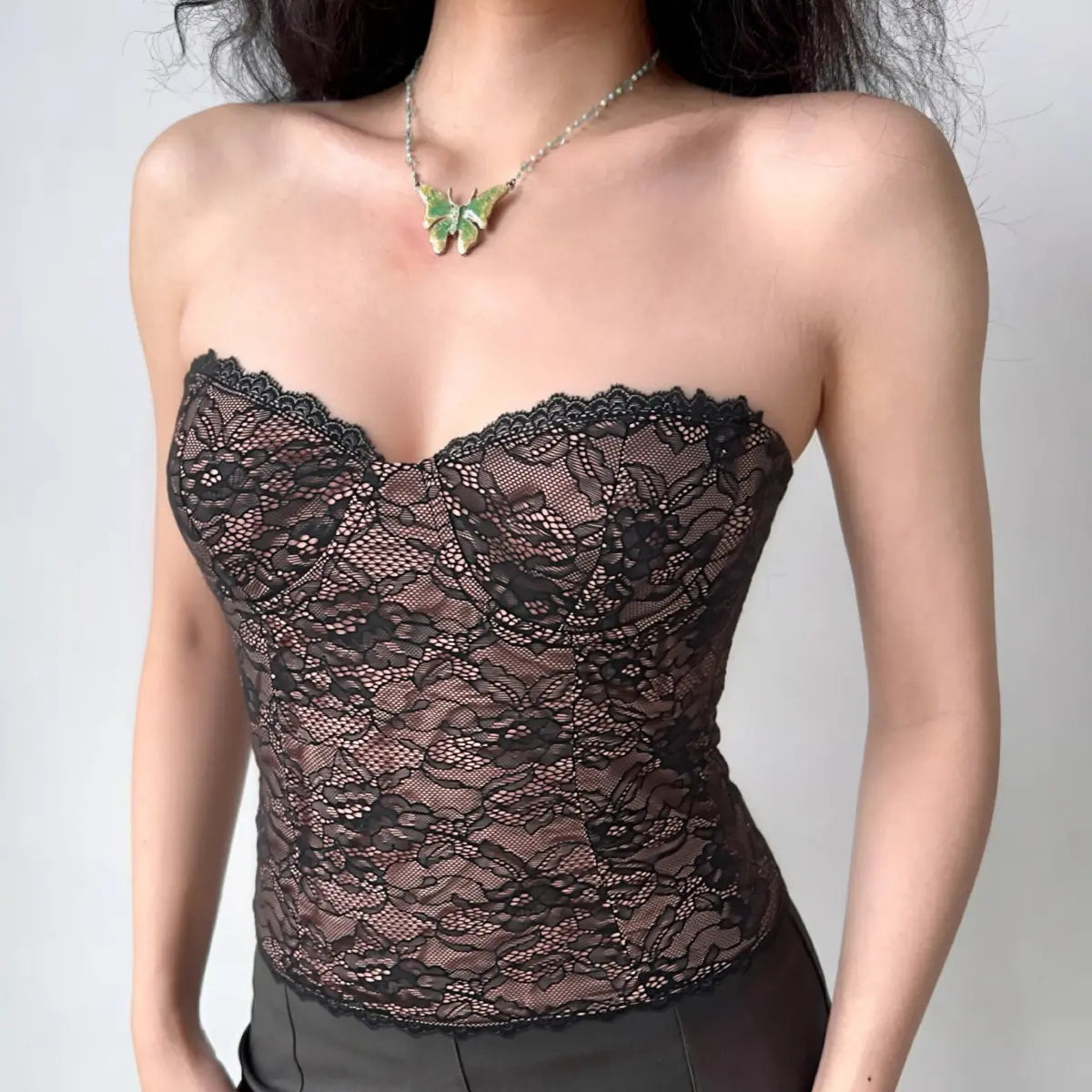 Model wearing black lace strapless corset top with sweetheart neckline, vintage-inspired sheer bustier