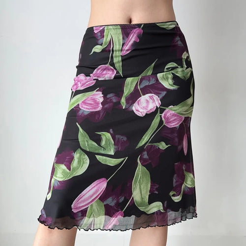 Close-up front view of model wearing black tulip print mesh midi skirt