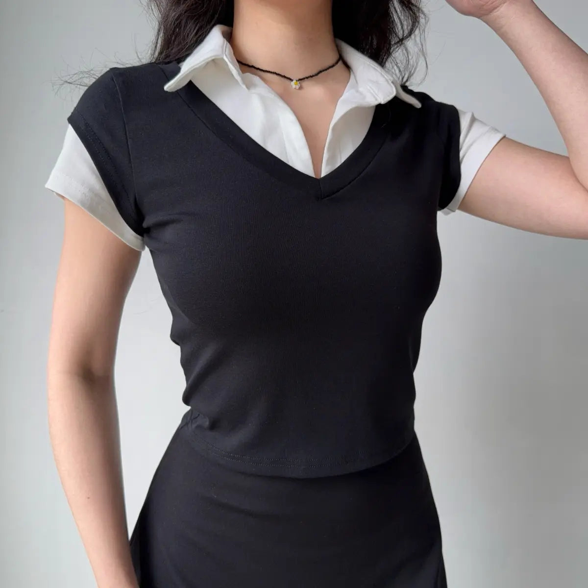 Front view of black faux two-piece dress showing the layered white collar and sleeve design