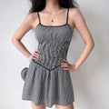 Model wearing black and white gingham smocked cami dress