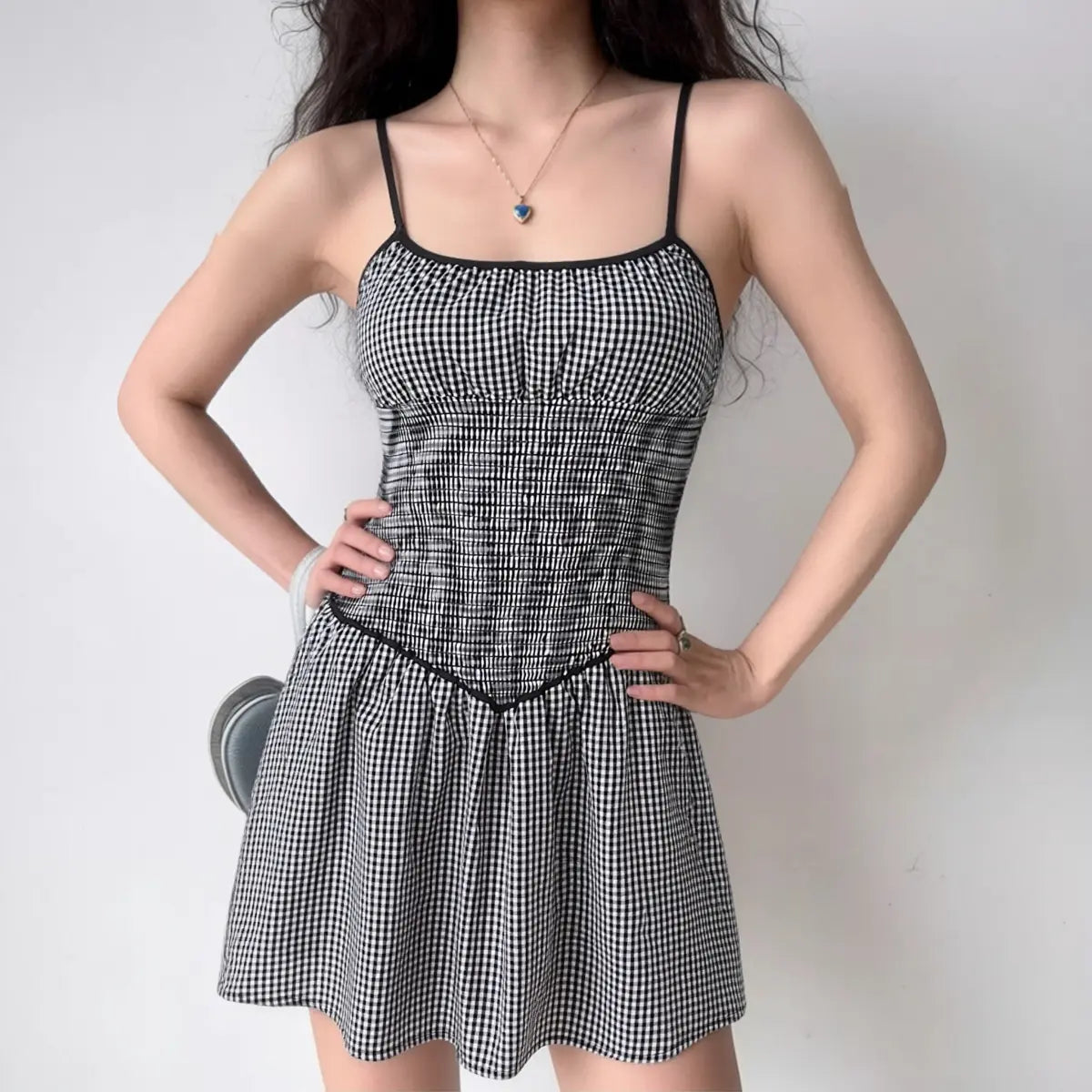 Model wearing black and white gingham smocked cami dress