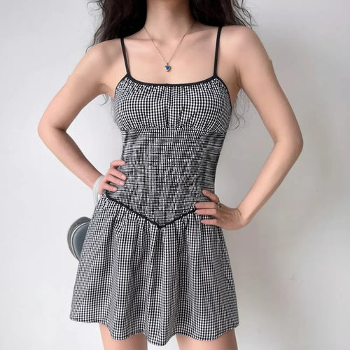 Model wearing black and white gingham smocked cami dress