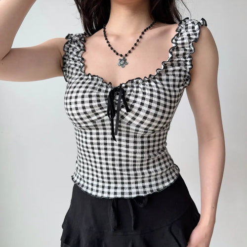 Outfit view of black and white gingham cami top styled with black bottoms, highlighting the fitted design