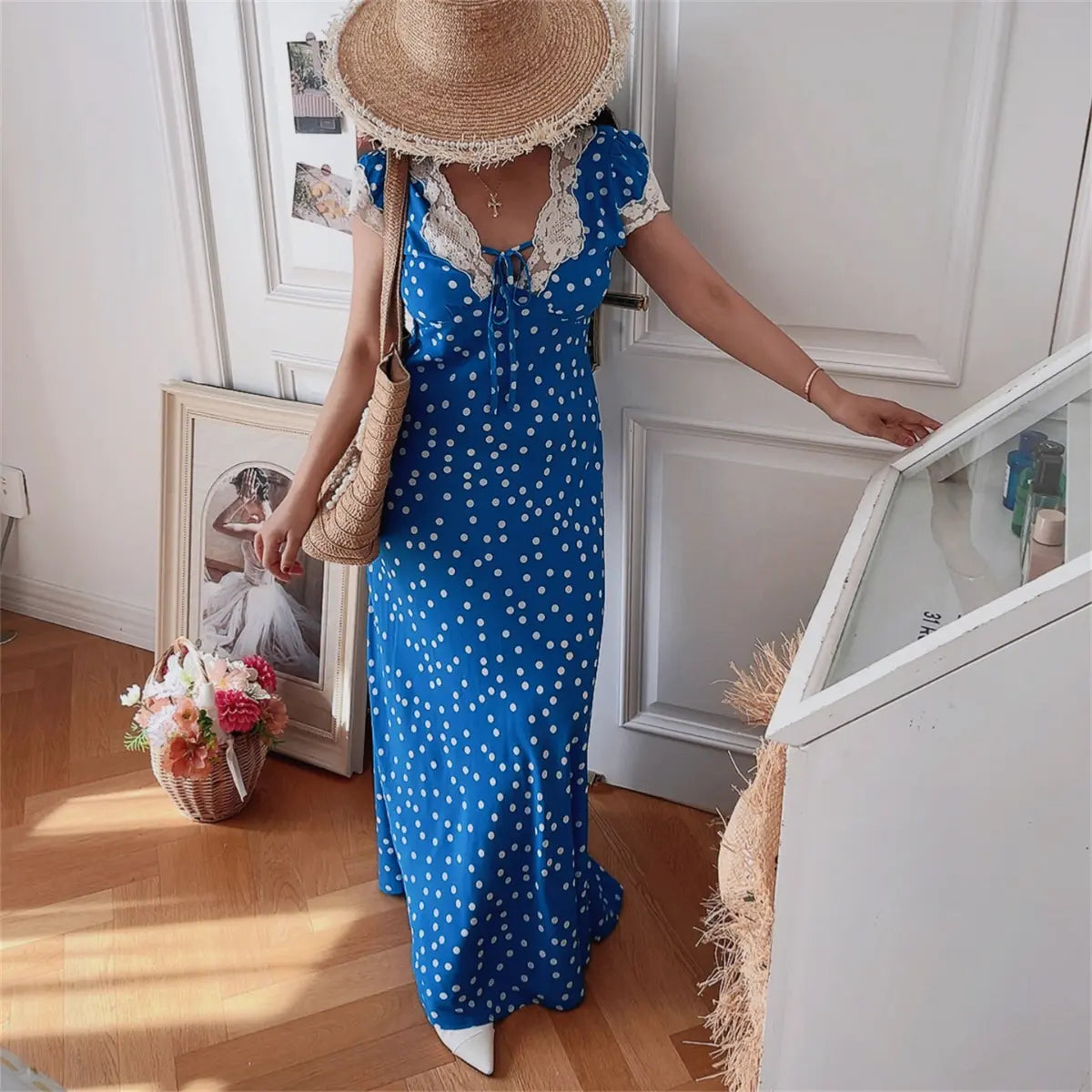 Model walking in blue ditsy print lace-trim maxi dress, front view
