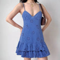 Model wearing blue eyelet floral cami dress with tiered ruffle hem, feminine bohemian mini dress