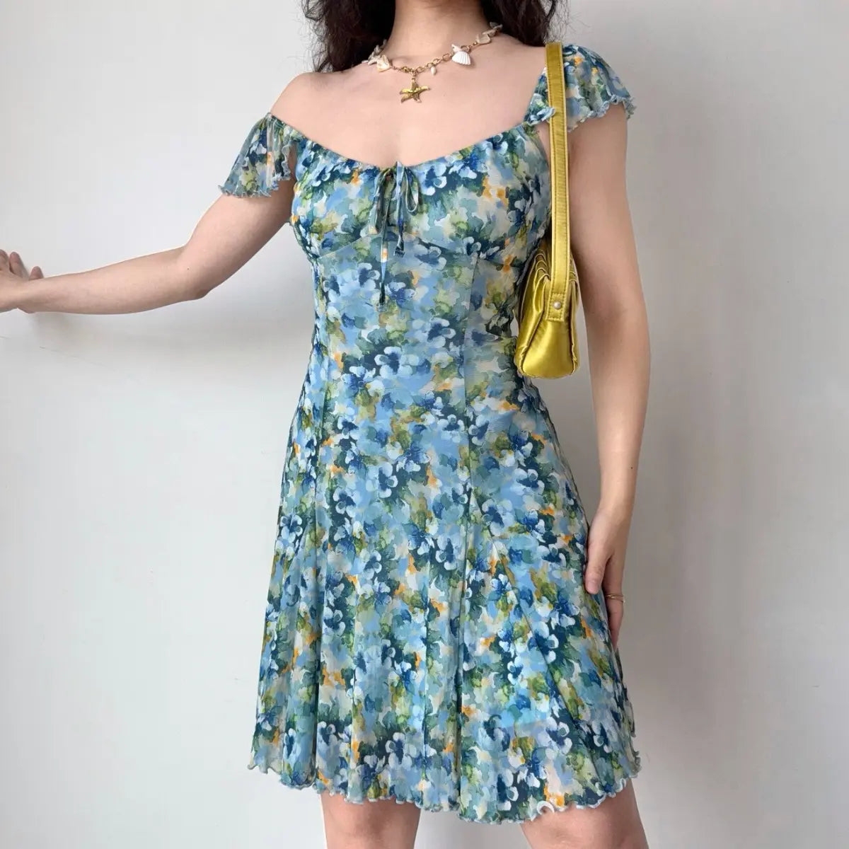 Three-quarter view of blue floral off-shoulder dress