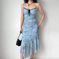Model wearing blue floral mesh cami and midi skirt set, full front view, handbag pose