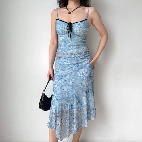Model wearing blue floral mesh cami and midi skirt set, full front view, handbag pose