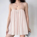 Model wearing blush pink cami dress with thin straps and bubble hem, flowy airy slip dress
