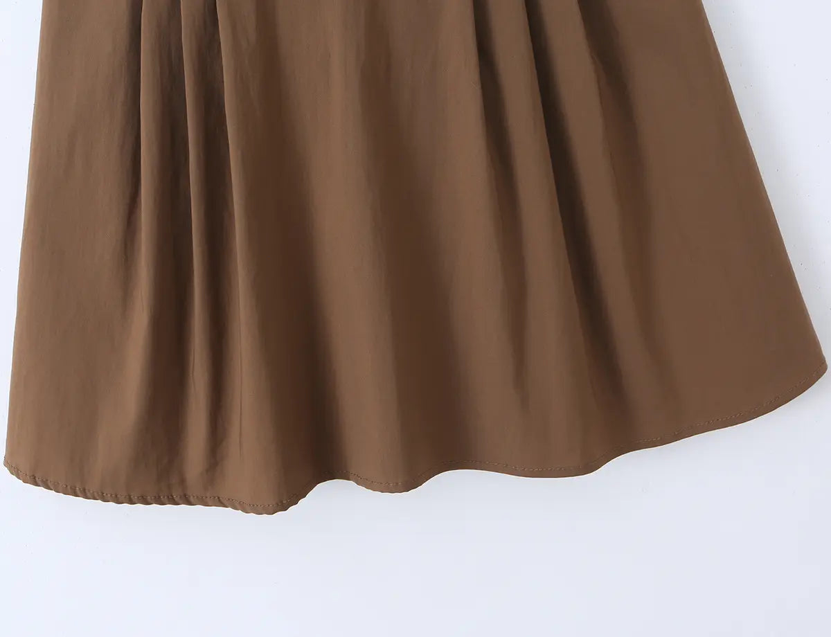 Close-up of flared ruffled hem on the brown cami dress, showing fabric drape