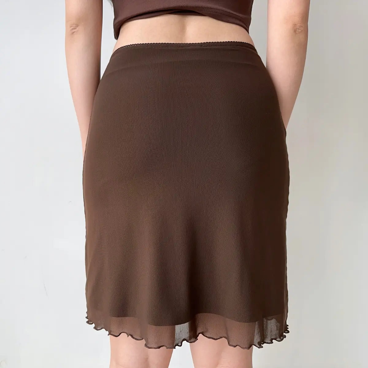 Model wearing brown mesh midi skirt, back view