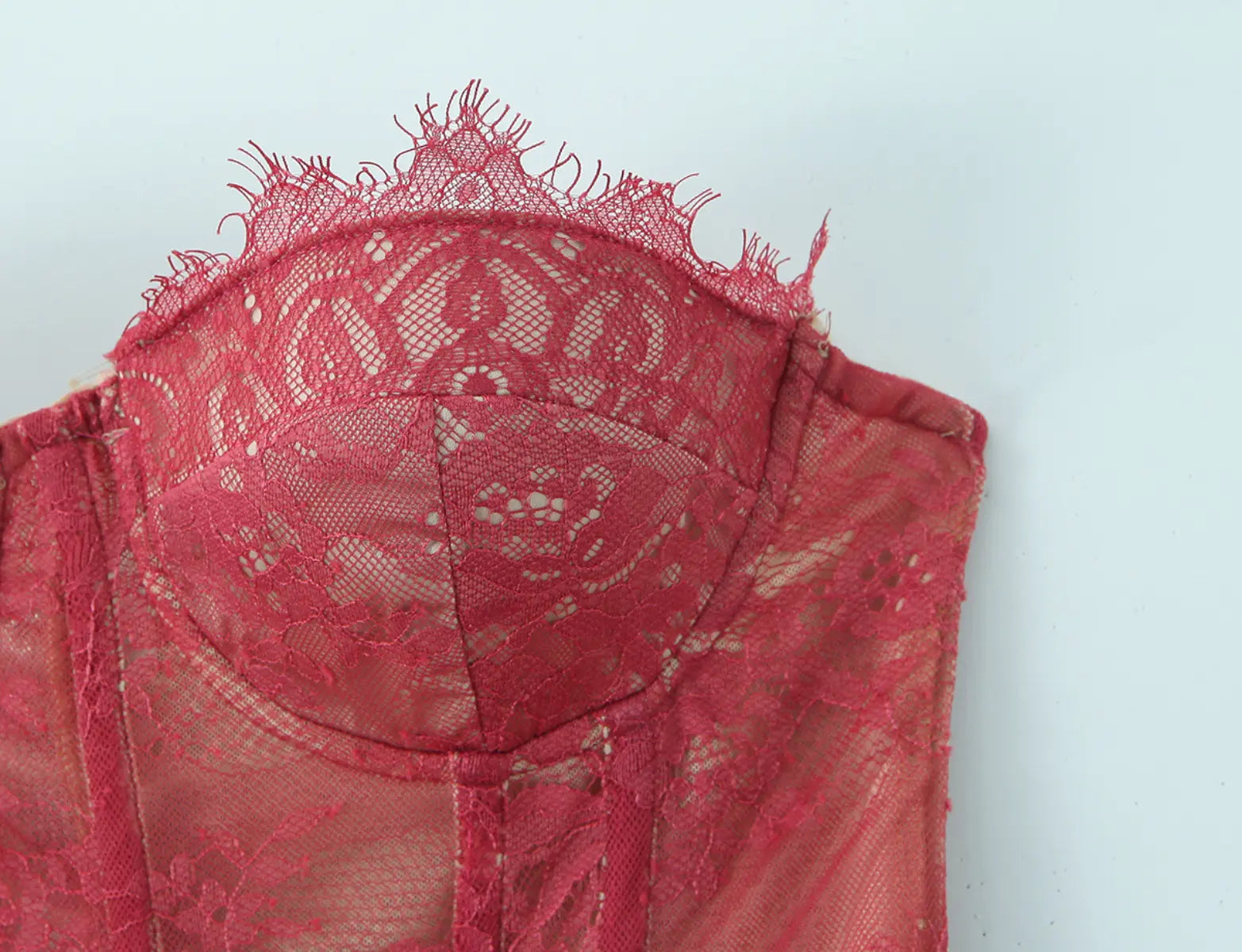 Close-up of burgundy lace corset top on model