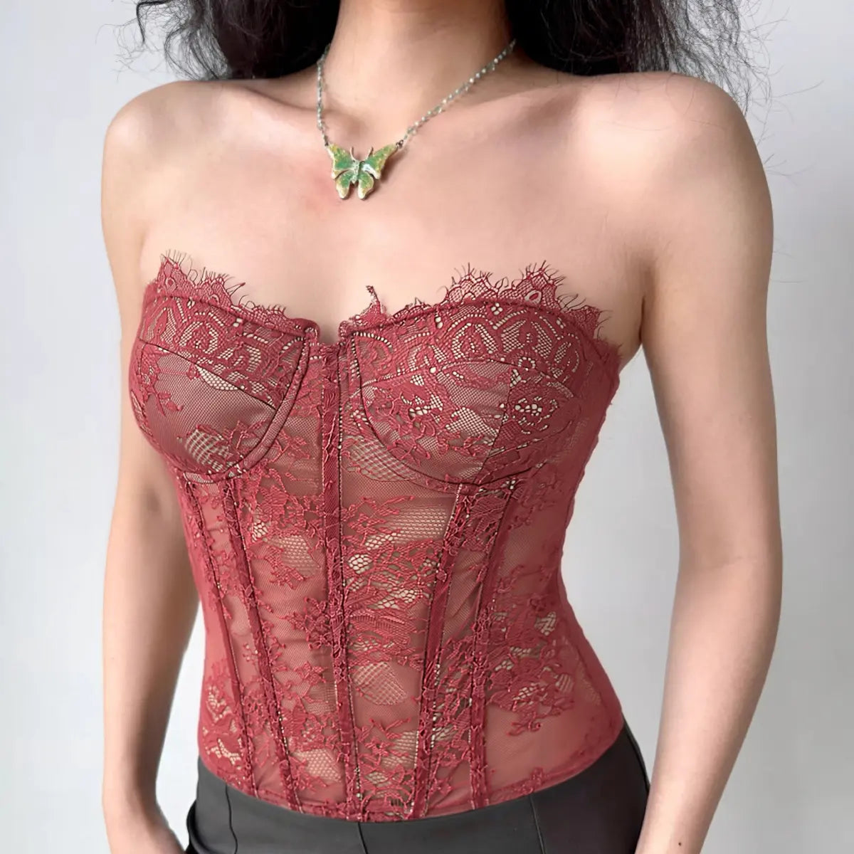 Model wearing burgundy lace strapless corset top, front view