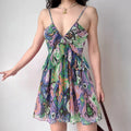 Model wearing colorful ikat print spaghetti-strap mini dress with tiered ruffle hem, bohemian summer dress