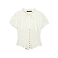 Front view of cream smocked tie-neck blouse