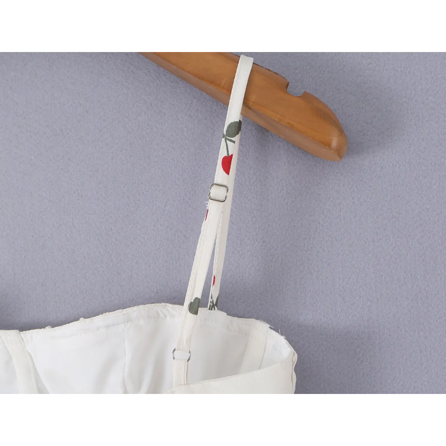 Close-up of thin printed spaghetti strap with silver metal slider adjuster buckle
