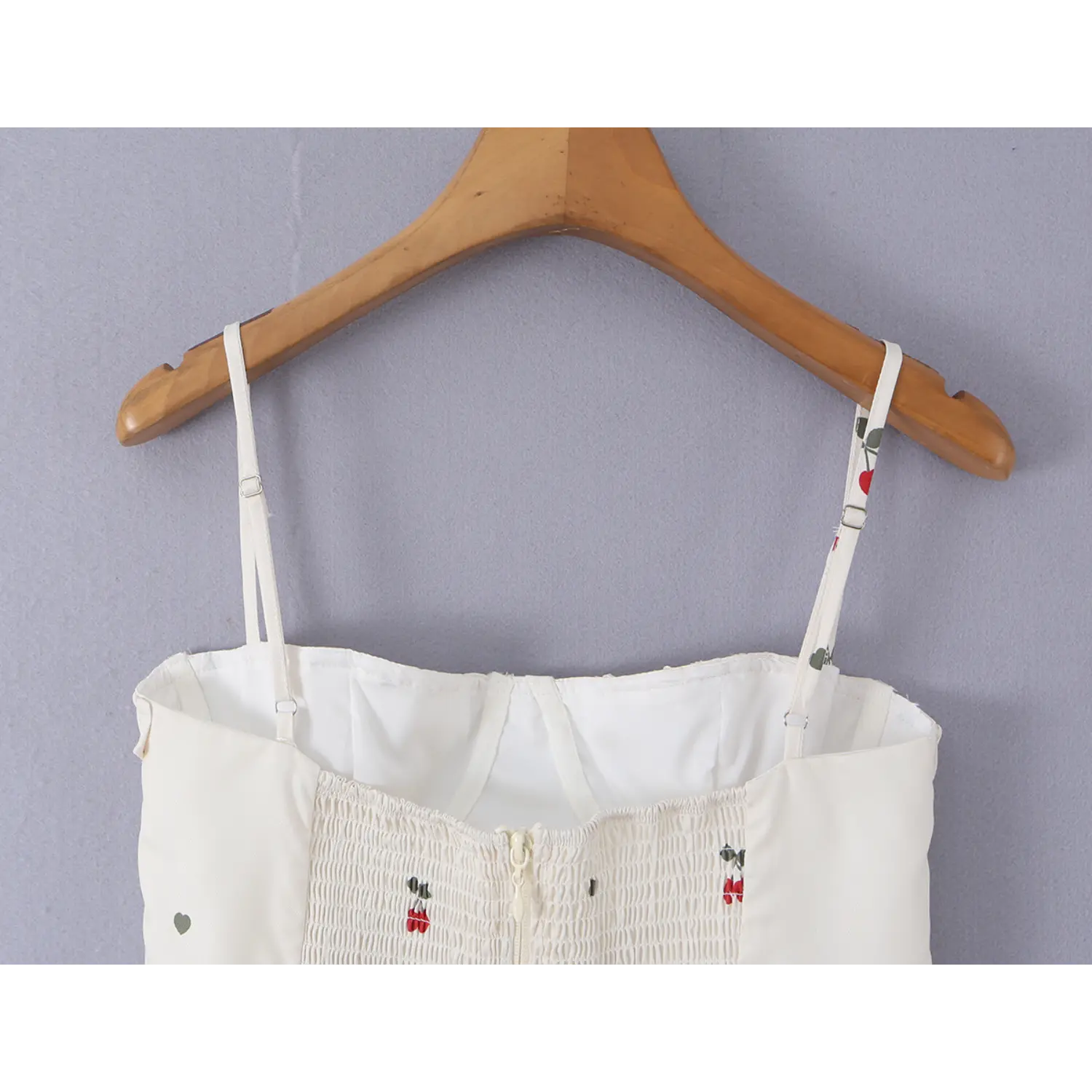 Full back hanging shot, showing adjustable printed spaghetti straps, inner lining and elastic smocked panel