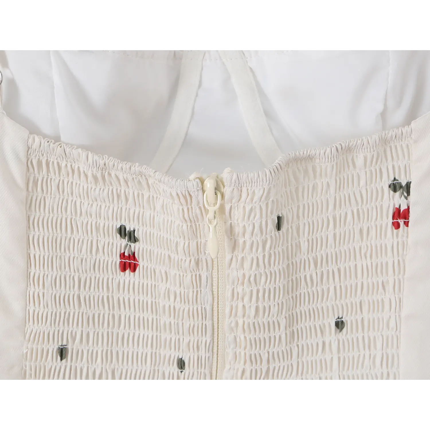 Back center invisible zipper close-up with elastic smocked stretch fabric and mini cherry heart prints