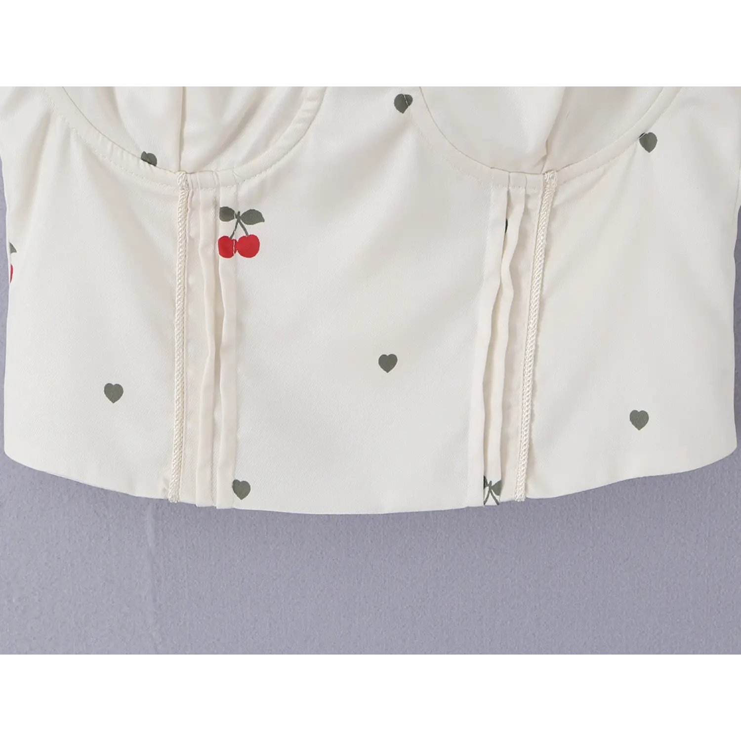 Full front torso detail showing double vertical decorative seams and scattered cherry heart prints