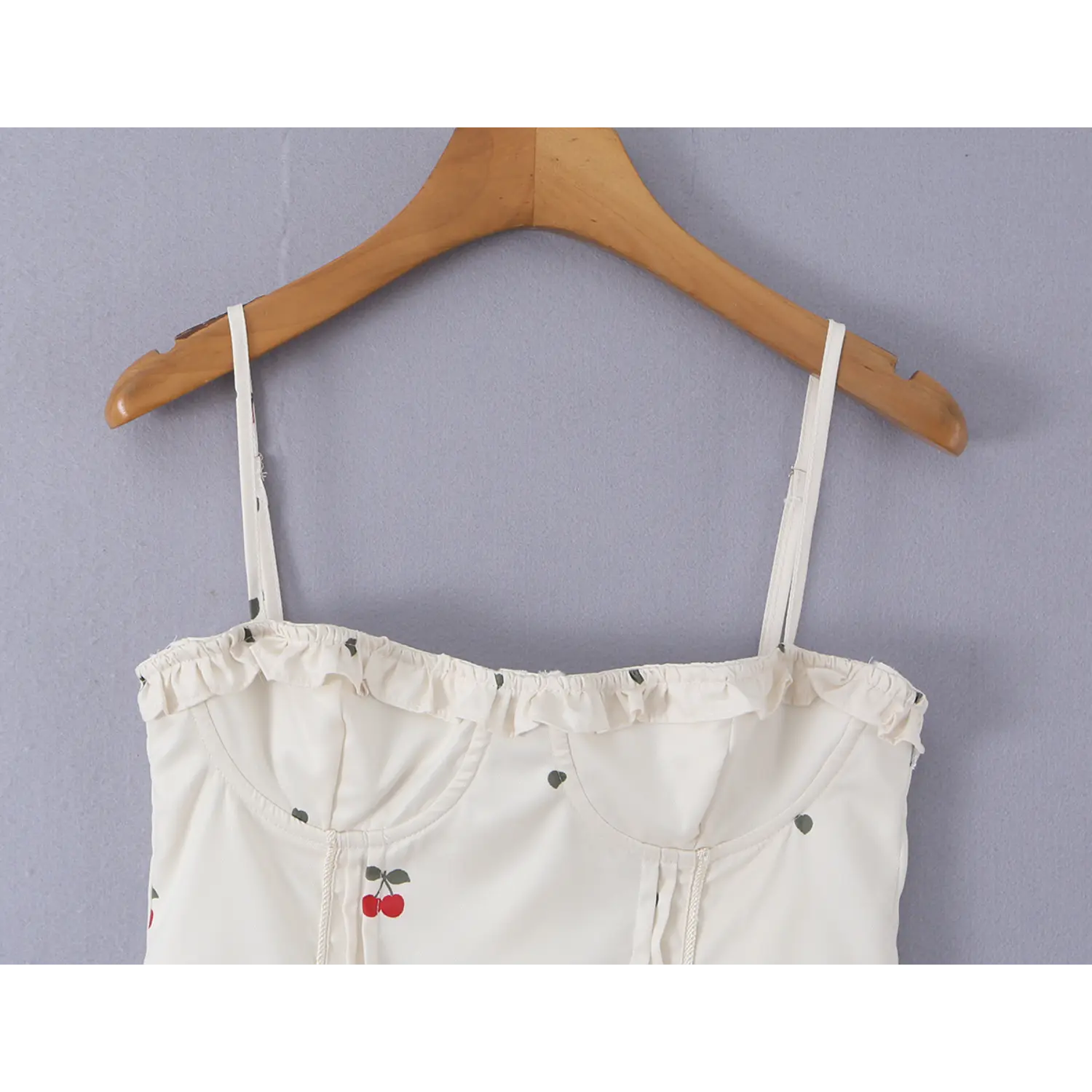 Close-up of ruffle frill neckline and structured bust stitching on cream cherry print corset cami top