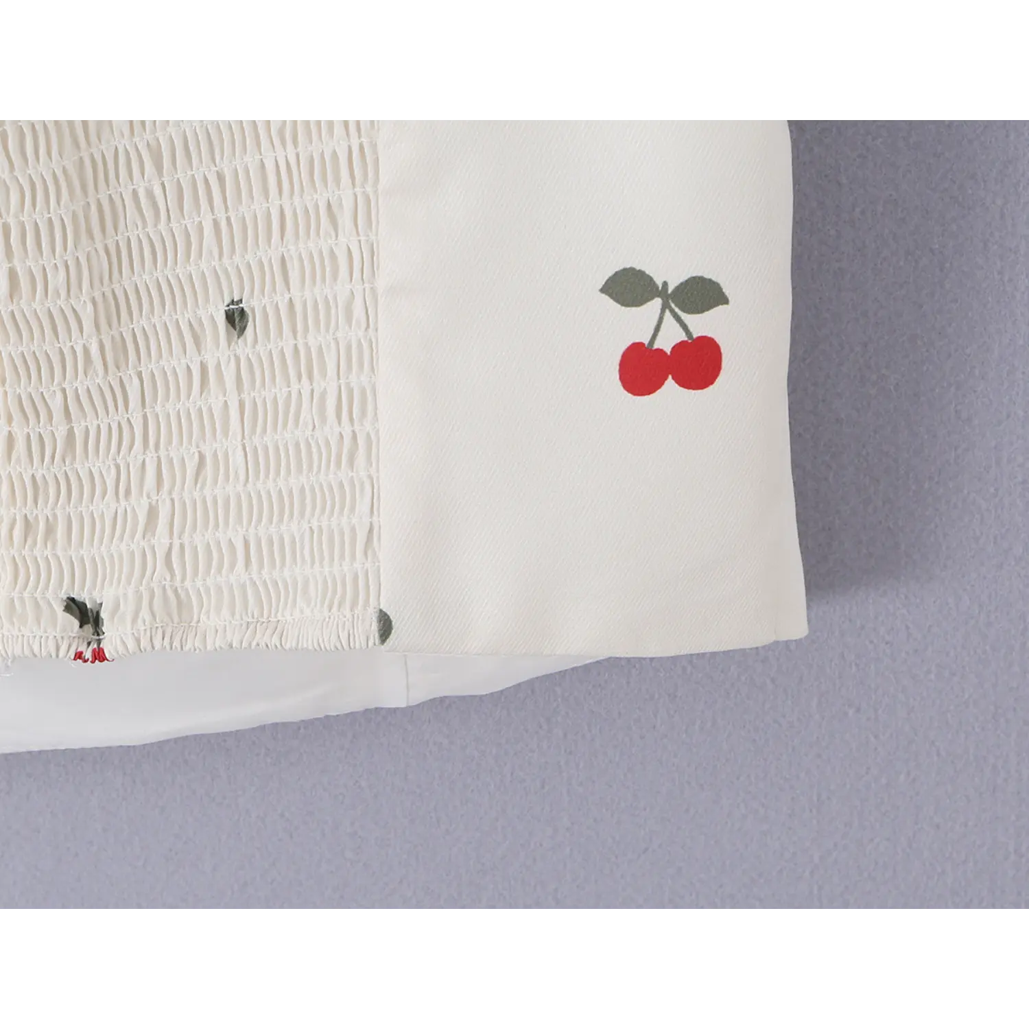 Side hem fabric detail, contrast between elastic smocked back panel and smooth front woven fabric with cherry print
