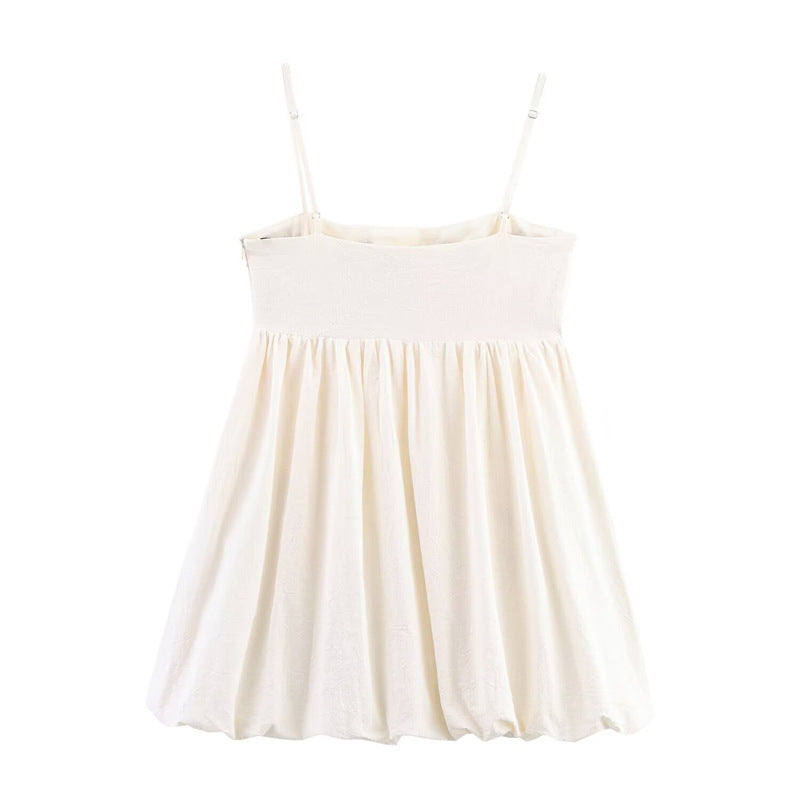 Back view of cream cami mini dress with solid color back and smocked panel