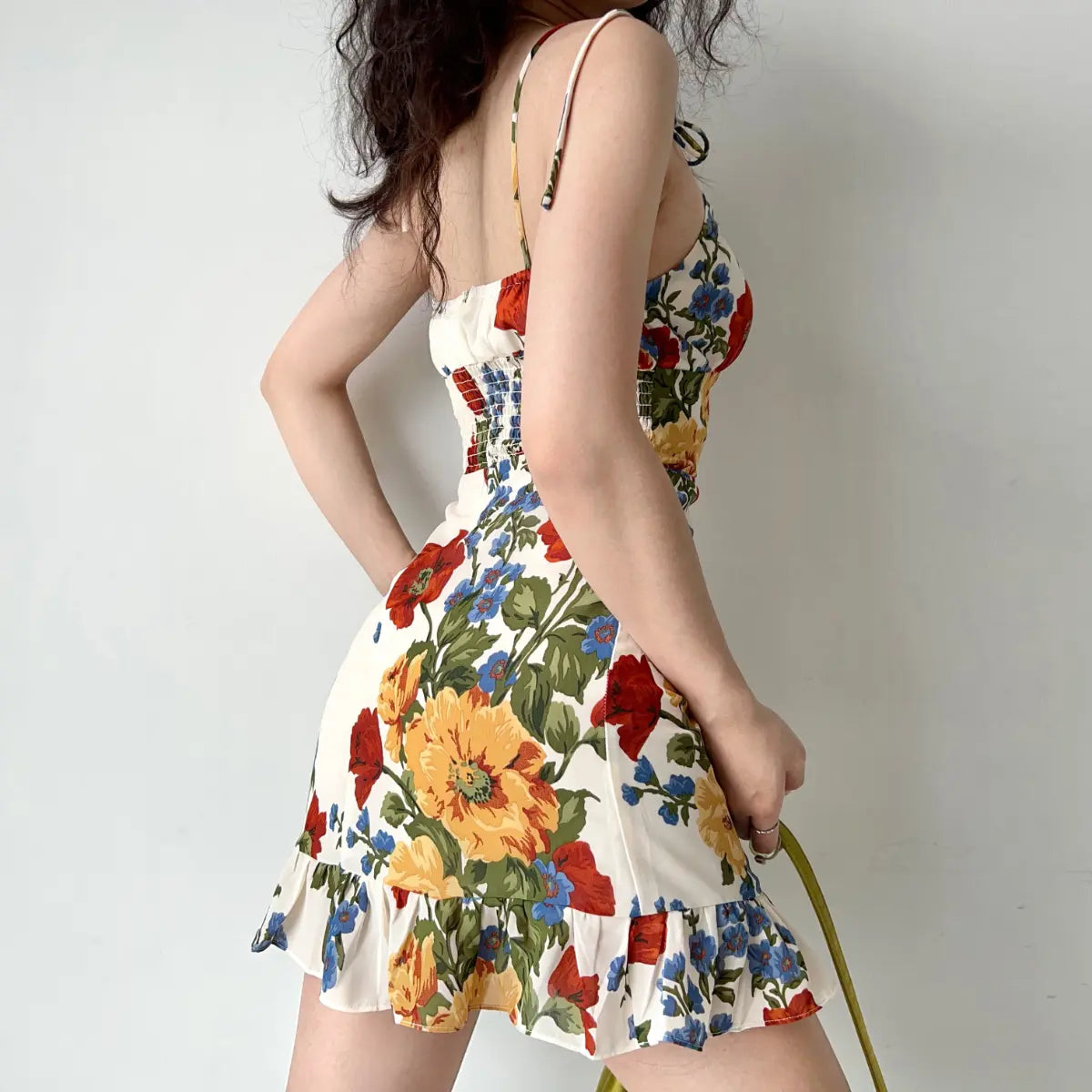 Back view of cream floral print cami dress with tie straps and form-fitting design