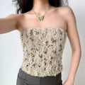 Model wearing cream sequin fuzzy strapless corset top, glamorous party-ready bustier-style top
