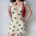 Model wearing cream white black floral print dress with keyhole front detail, vintage-inspired bodycon dress