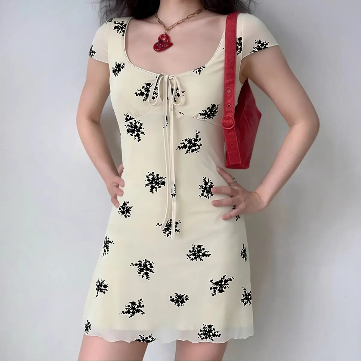 Model wearing cream white black floral print dress with keyhole front detail, vintage-inspired bodycon dress