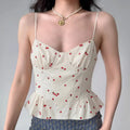 Model wearing cream white cherry-print cami top with peplum ruffle hem, cute corset-style spaghetti-strap top
