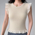 Model wearing cream white lace-knit top with ruffle sleeves and hem, textured feminine blouse