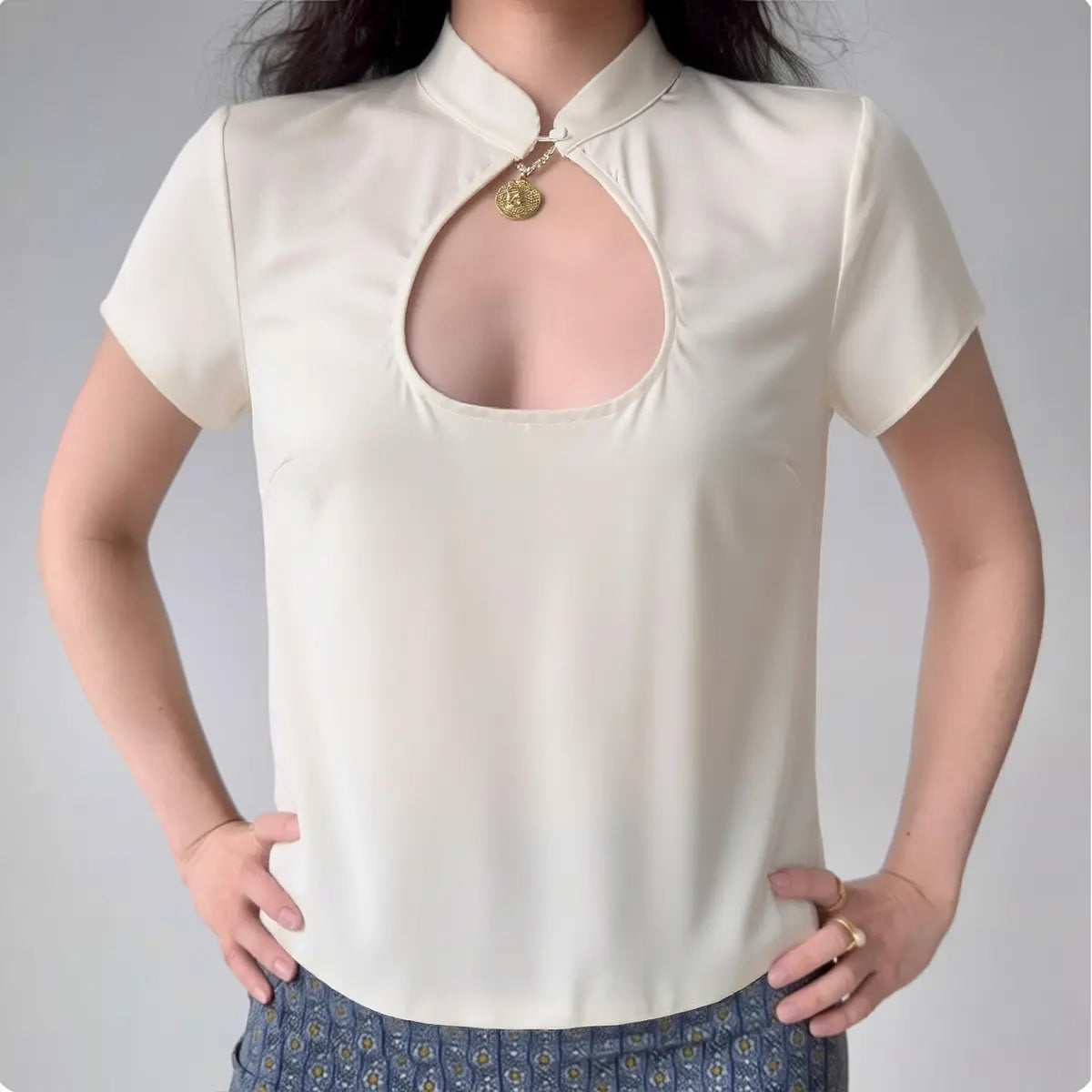 Model wearing cream white blouse with mandarin collar and keyhole cutout, elegant short-sleeve top
