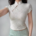 Model wearing cream white qipao-style top with short sleeves and cropped hem