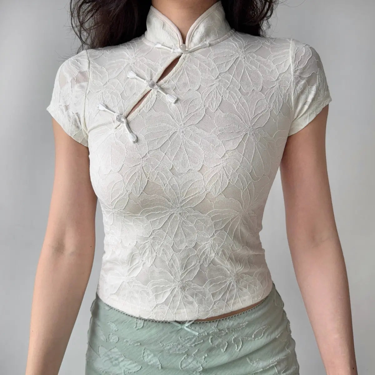 Outfit view of cream white qipao-style top styled with light green skirt