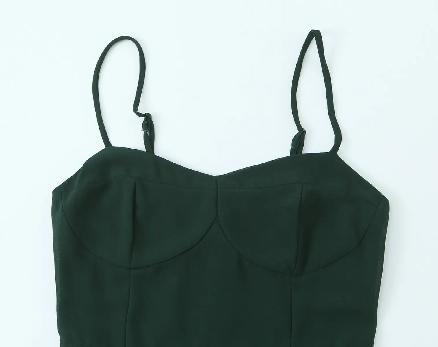 Bodice detail view of dark green cami mini dress on white background