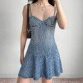 Model wearing denim cami dress with bustier-style bodice and flare hem, retro-inspired mini dress