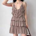 Model wearing dusty pink halter-neck ruffled mini dress with tiered skirt