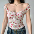 Front view of white floral cami top showing the ruffled straps, sweetheart neckline, and fitted corset-style bodice